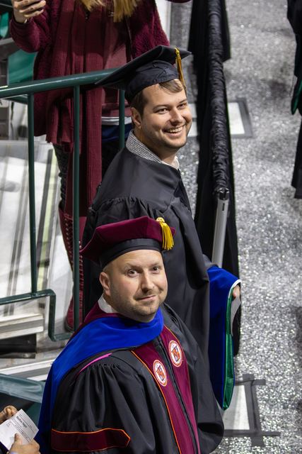A doctoral candidate being hooded at a commencement ceremony.