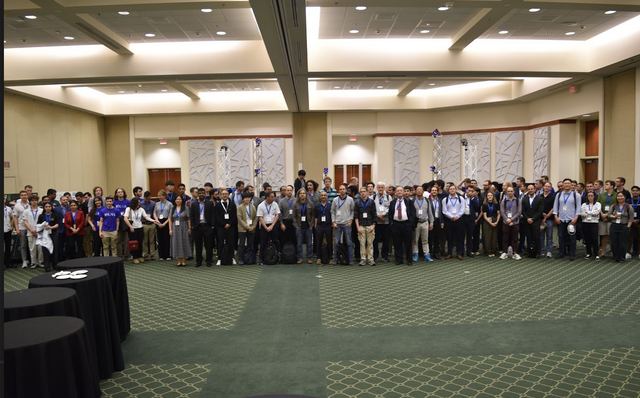 A large ballroom filled with conference attendees.